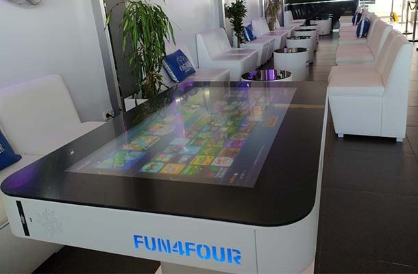 Hvidt 43" Fun4Four digital spillebord står på gulvet med hvide stole ved siden